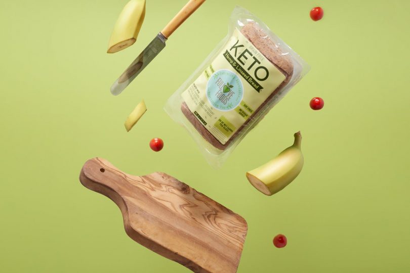 keto bread wooden chopping board with knife and fork sliced banana and cherry tomatoes